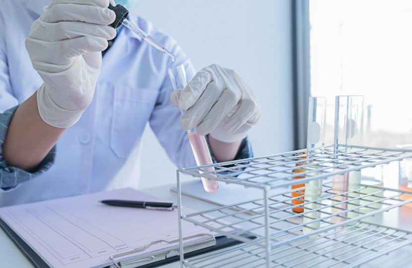 Scientist samples liquid into a testing pot.