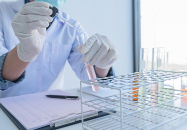 Scientist samples liquid into a testing pot.